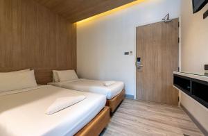 曼谷水门皮瑞德酒店的小房间设有两张床和电视