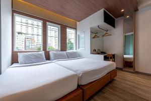 曼谷水门皮瑞德酒店的卧室设有白色大床和窗户。