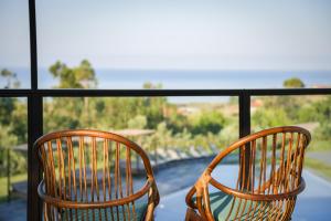 吉泽里亚Hang Loose Cottage的两把椅子坐在一个眺望着大海的阳台