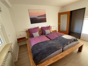 巴特哈尔茨堡Ferienwohnung Elfengast, FassSauna, Harzurlaub in bester Lage的一间卧室配有一张带紫色床单的大床