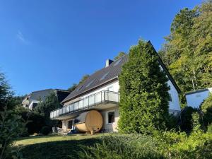 巴特哈尔茨堡Ferienwohnung Elfengast, FassSauna, Harzurlaub in bester Lage的一座大树白色房子