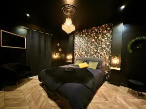 昂热Love Room Secrète Les Petits Plaisirs的一间卧室配有一张大床和一个吊灯。