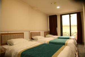 埃尔比勒Syros Hotel Erbil City Center的一间房间里三张床的组合