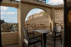埃尔比勒Syros Hotel Erbil City Center的阳台配有桌椅和墙壁。