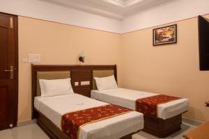 纳盖科伊尔Hotel Vashanth Krishna的配有两张床的酒店客房中的两张床