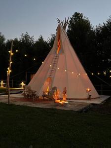 LembekeComfort Tipi Marie, Tipi Bo Deluxe & tent Nicolaï - 'Glamping in stijl'的女人站在一个大的白色帐篷里