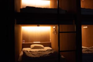别府Guesthouse Sunline Beppu的客房设有一张双层床,上面有灯