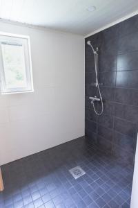 卡亚尼Lomaperkkiö Cottages的浴室设有蓝色瓷砖和淋浴。