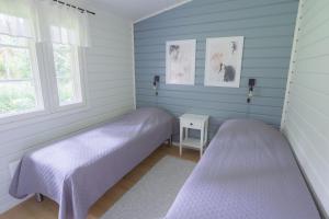 卡亚尼Lomaperkkiö Cottages的配有两张床铺的蓝色墙壁和窗户
