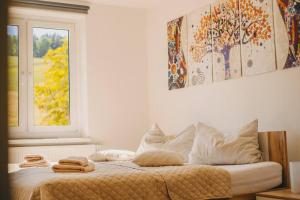 AuerbachFranzis Feriendomizil im Herzgebirge am Skihang的卧室配有带枕头的床铺和窗户。