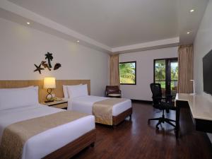 卡乌罗西姆果阿假日酒店的酒店客房配有两张床和一张书桌