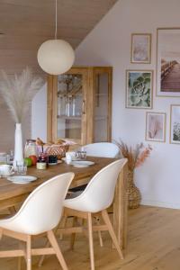 哈里斯莱Frühlingsbogen的一间带木桌和白色椅子的用餐室