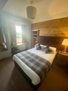 穆塞尔堡拉瓦尔斯顿之家酒店的一间卧室配有一张大床和一张铺着条纹毯子