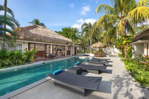 龙目岛库塔KU Villas的一个带躺椅的游泳池和一个度假村
