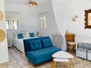 比纽埃拉La Rústica en Viñuela, piscina privada的一间卧室配有一张床和一张蓝色的沙发