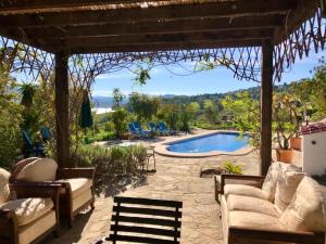 比纽埃拉La Rústica en Viñuela, piscina privada的一个带椅子的庭院和一个游泳池