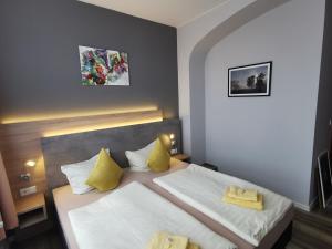 萨勒河畔瑙姆堡阿尔特费尔斯柯勒宾馆的一间卧室配有一张带黄色枕头的大床