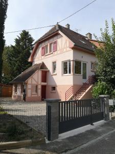 StaffelfeldenLe logis du mineur Chez Agnès et Joël的粉红色的房子,前面有栅栏