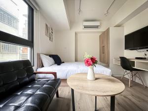 台中市旅行家 Affetto Hostel的带沙发、床和桌子的客厅