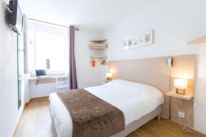 马赛欧洲酒店的一间卧室配有一张床、一张书桌和一个窗户。