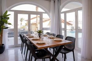 埃拉特YalaRent Ivy Villa with Private Pool的一间带桌椅和窗户的用餐室