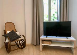 BronzoloGerwies-Hof的椅子旁的电视架上配有平面电视