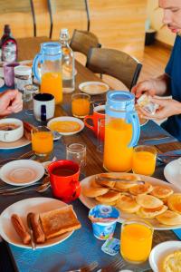 OmadhooHudhuvelimaldives的餐桌上摆放着早餐食品和橙汁盘