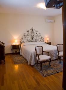 萨奇莱利文萨酒店的一间卧室配有一张带两把椅子和两盏灯的床。