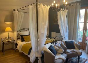 伊泰尔斯维莱基弗酒店的一间卧室配有一张天蓬床和两把椅子