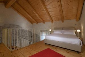 塞拉伦加达尔巴Cà 'd Calin Casa nel Borgo的卧室设有白色的床和木制天花板。