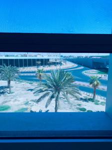 Al Fayşalīyahشقق الروشن الجوفي的从窗户可欣赏到棕榈树度假村的景色