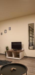 蒂米什瓦拉CBT Apartament的客厅配有餐桌上的平面电视