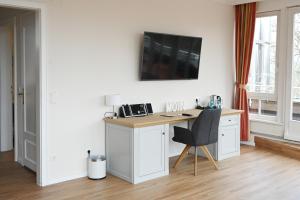 霍瓦赫特瑞恩湖贺瓦查特酒店的客房设有一张桌子、一把椅子和一台墙上的电视