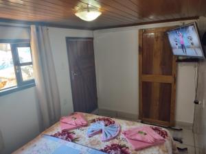 阿布拉奥Hospedagem capitão Hula的一间卧室,床上有粉红色的衣服