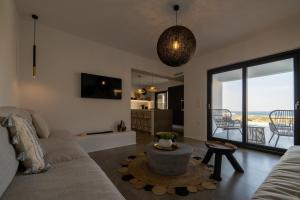 米科利维亚Villa Unica - Mikri Vigla, Seaview, Pool & Jacuzzi的带沙发的客厅,享有海景