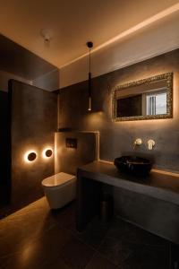 米科利维亚Villa Unica - Mikri Vigla, Seaview, Pool & Jacuzzi的一间带水槽、卫生间和镜子的浴室