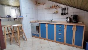 科尔尼奇House Elan的厨房配有蓝色橱柜和水槽