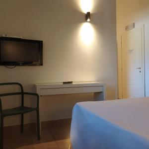 罗马卢克萨德酒店的一间卧室配有一张床、一张书桌和一台电视