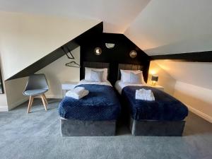 罗瑟勒姆Kimberworth House, 4 Bedrooms, WIFI, Close to M1, Longer Stay, Free Parking的一间卧室配有两张带蓝色毯子和椅子的床