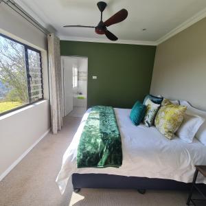 BergviewLuxury Home with breathtaking views of Champagne Valley的一间卧室配有一张大床和吊扇