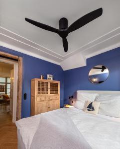 瓦尔内明德Warnemünde: Apartment KAJÜTE - nur 3 Gehminuten zum Strand的蓝色卧室配有一张带吊扇的床