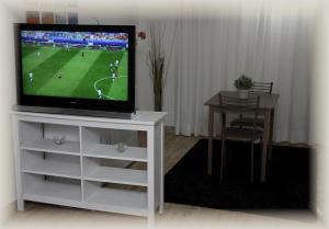 坎帕尼亚诺·迪罗马Just House的客厅配有一台电视,位于带桌子的白色台面上
