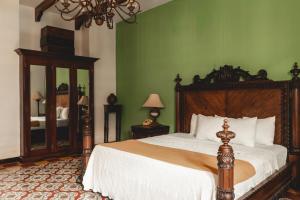 格拉纳达格兰弗朗西亚餐厅酒店的一间卧室设有一张大床和绿色的墙壁