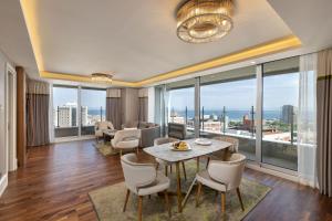 伊斯坦布尔泰坦尼克港口巴克科伊酒店的客厅配有桌椅和大窗户