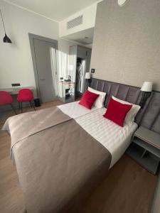 TõrvaTõrva Veemõnula Spaahotell的一间卧室配有一张带红色枕头的大床