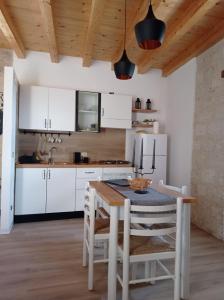 佩特拉利亚索普拉纳Casa Vacanze Borgo Gulini da Anna的厨房配有白色橱柜和桌椅