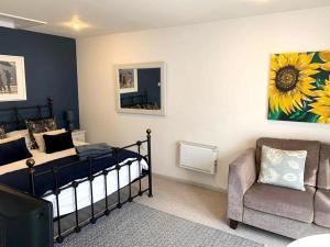 Marnhull红豆杉树美景公寓的一间卧室配有一张床、一把椅子和一张沙发