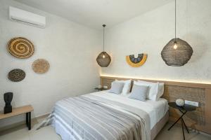 依拉佩特拉Okeanis Mystique South的一间卧室配有一张床和一些吊灯