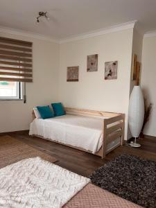 科英布拉Deluxe Studio com terraço e varanda privada - 'Casinha da Amoreira' Guesthouse的一间卧室配有一张带蓝色枕头的床