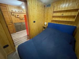 阿巴迪亚圣萨尔瓦托雷Chalet I Folletti的一间卧室设有蓝色的床和木墙